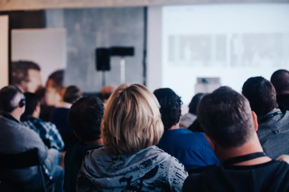 Publikum vor einer Präsentationsleinwand